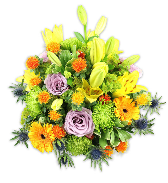 Set against a stark white backdrop, this densely packed floral arrangement reads like a small garden gathered into a single, elegant mound. The composition is anchored by several tall yellow Asiatic lilies, some with petals fully open to reveal speckled throats and stamens, others still as sleek buds that add upward motion and promise of more bloom. Two or three soft lavender-purple roses are placed near the visual centre, their layered petals turning inward and offering a cool, romantic anchor to the vivid warm tones. Bright orange Gerbera daisies, with their radiating flat petals around darker centers, punctuate the arrangement and draw the eye across the surface. Chartreuse-green button chrysanthemums fill and cushion the bouquet, creating a tactile, almost plush foundation, while tiny spiky orange and yellow globe accents lend playful texture and bright punctuation. Several blue-grey Eryngium sea thistles emerge from the lower planes and flanks, their star-like bracts and steel-blue hue giving the piece an unexpected, contemporary edge. A mix of broad lily leaves and smaller glossy greenery provides depth, shadow and a unifying verdant backdrop that balances the lively colour palette. Soft studio lighting reveals petal sheen and the subtle scent of lilies and roses; overall, the arrangement conveys celebration, thoughtful sympathy, or uplifting home décor. It's the sort of bouquet I'd recommend for a sunny breakfast table near Richmond Riverside or a thoughtful celebration in East Sheen, crafted with steady hands and an eye for harmony.